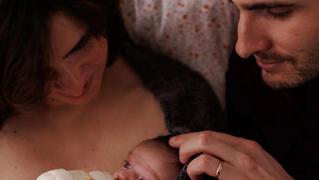 Des parents blottis contre leur nouveau-né, en peau à peau