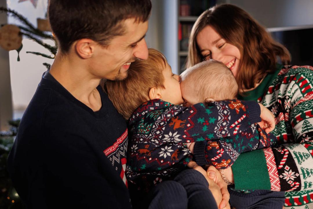Des parents serrent leurs deux jeunes enfants dans leurs bras
