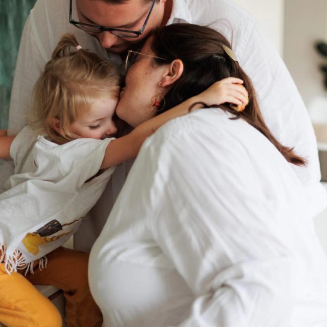 Une maman et sa fille s'embrassent, joue contre joue