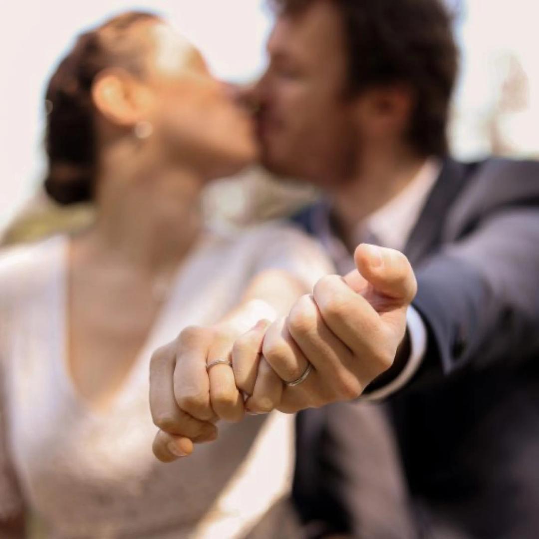 Un couple s'embrasse, les mains enlacées