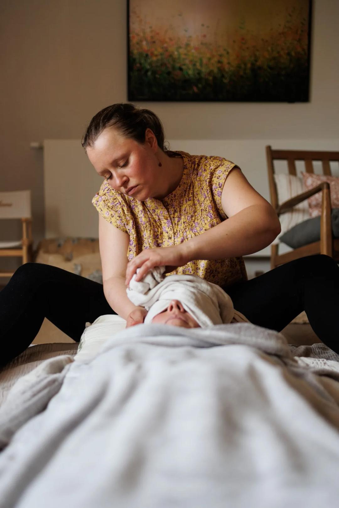 Une doula accompagne une femme allongée avec un rebozo