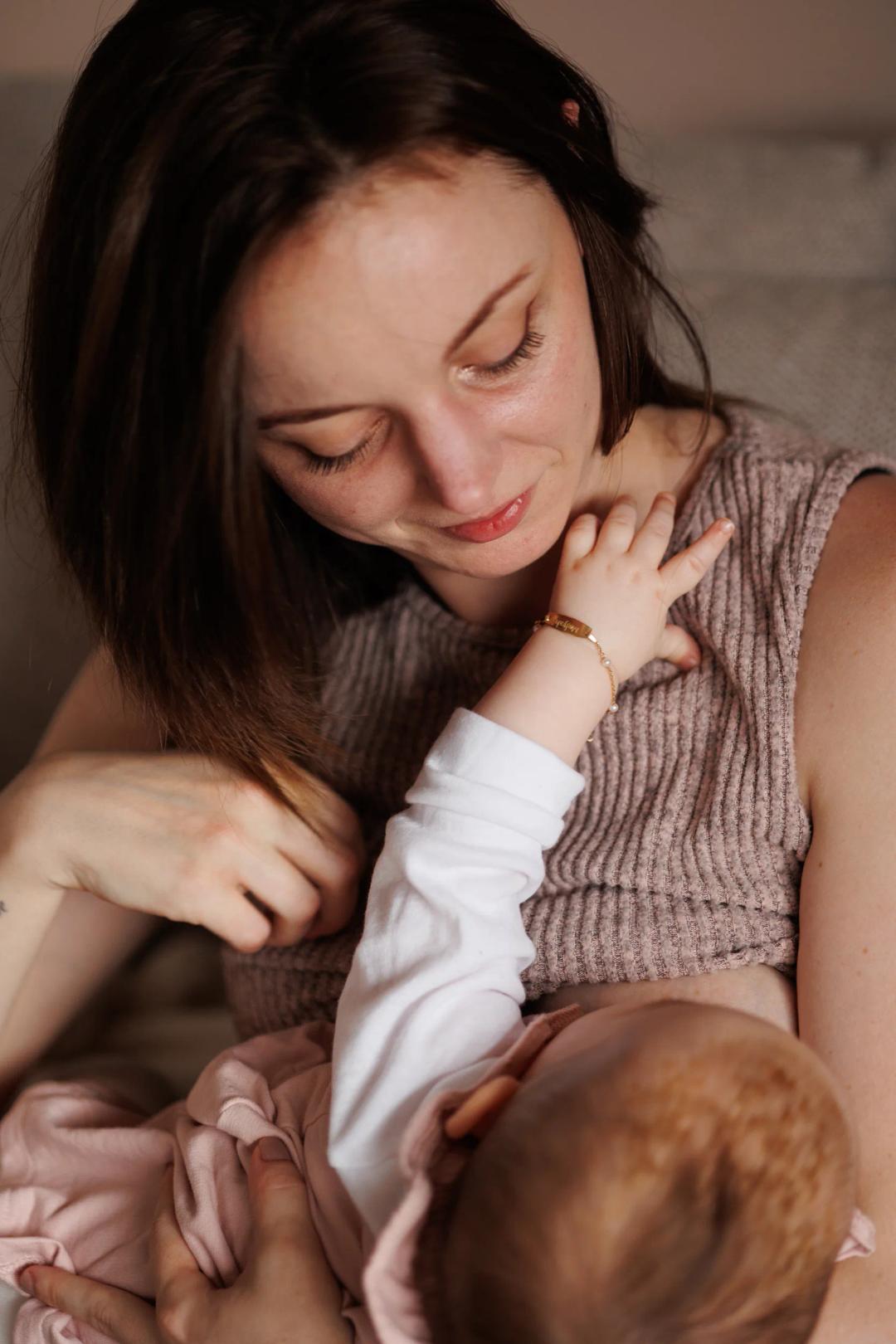 Une jeune maman regarde son bébé pendant la tétée