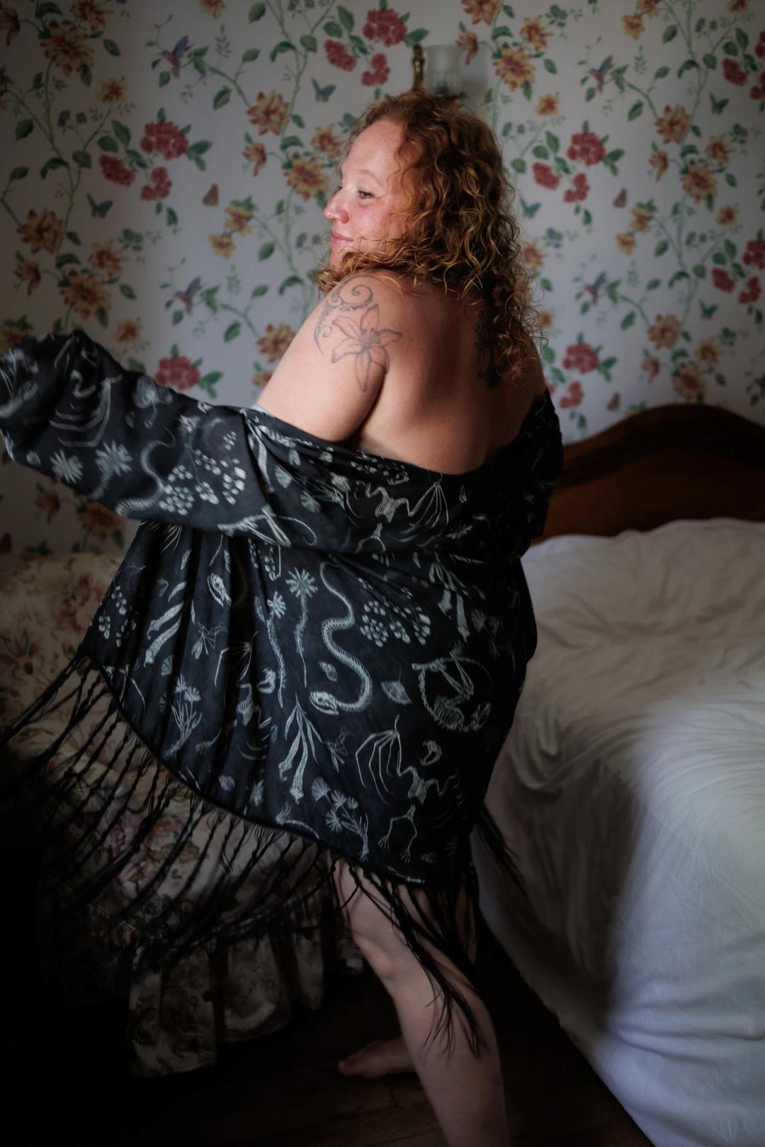 Une femme en kimono noir danse près de son lit